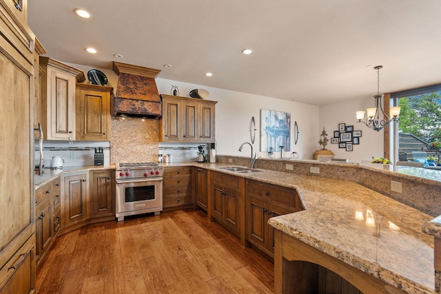 5675 US Highway 93 S Unit 10, Somers, MT 59932 - kitchen featuring premium range, a sink, custom range hood, brown cabinetry, and recessed lighting