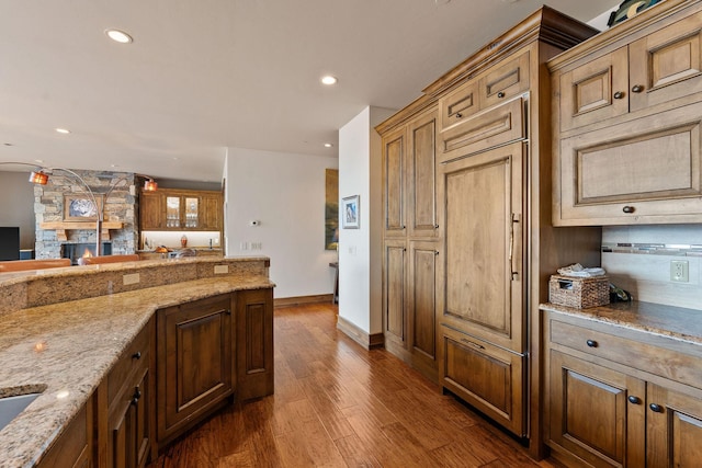 5675 US Highway 93 S Unit 10, Somers, MT 59932 - kitchen featuring dark wood-style floors, light stone countertops, recessed lighting, baseboards, and a fireplace