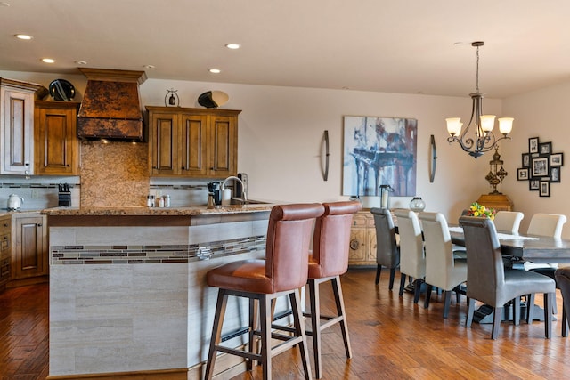 5675 US Highway 93 S Unit 10, Somers, MT 59932 - kitchen with custom exhaust hood, a breakfast bar, brown cabinets, dark wood-style floors, and recessed lighting