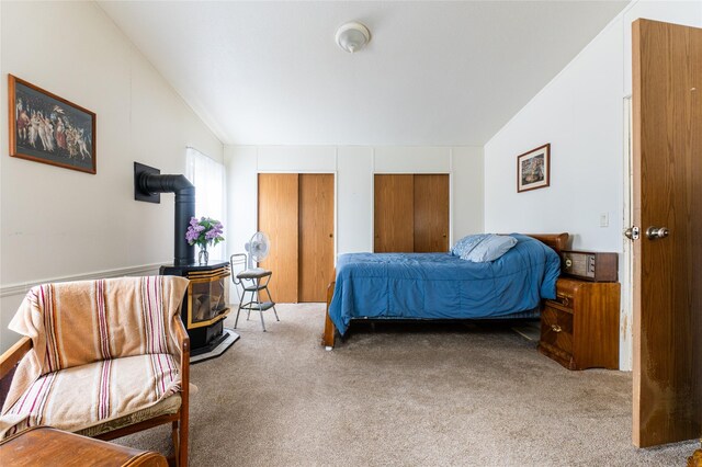 1709 20th Ave S, Great Falls, MT 59405 - bedroom featuring a wood stove, carpet, lofted ceiling, and two closets