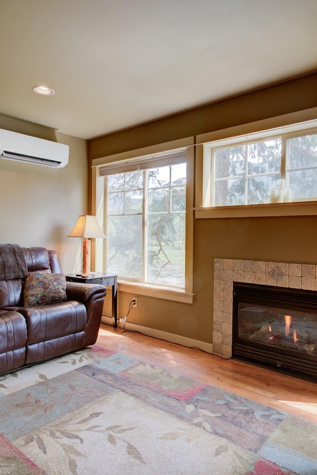 2055 Diamond Match Rd, Superior, MT 59872 - living area featuring a wall mounted air conditioner, plenty of natural light, wood finished floors, a fireplace, and recessed lighting