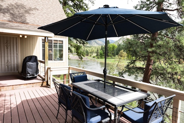 2055 Diamond Match Rd, Superior, MT 59872 - wooden deck featuring outdoor dining area, a grill, and a water and mountain view