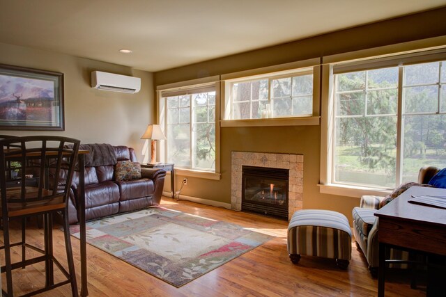 2055 Diamond Match Rd, Superior, MT 59872 - living room featuring a wall unit AC, baseboards, wood finished floors, a tiled fireplace, and recessed lighting