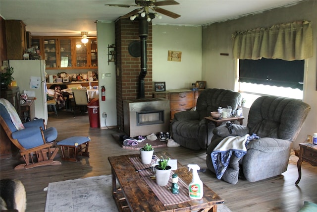 303 Swamp Creek Loop Rd, Trout Creek, MT 59874 - living room featuring a wood stove, ceiling fan, and wood finished floors