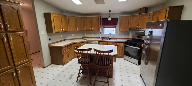 8 Teresa Ln, Great Falls, MT 59404 - kitchen featuring appliances with stainless steel finishes, light floors, brown cabinets, and under cabinet range hood