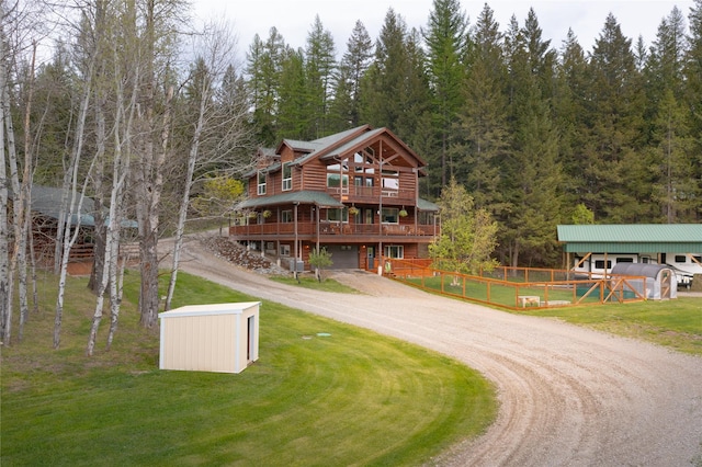 12520 Pinkham Creek Rd, Rexford, MT 59930 - log-style house featuring dirt driveway, an outdoor structure, a wooden deck, and a wooded view