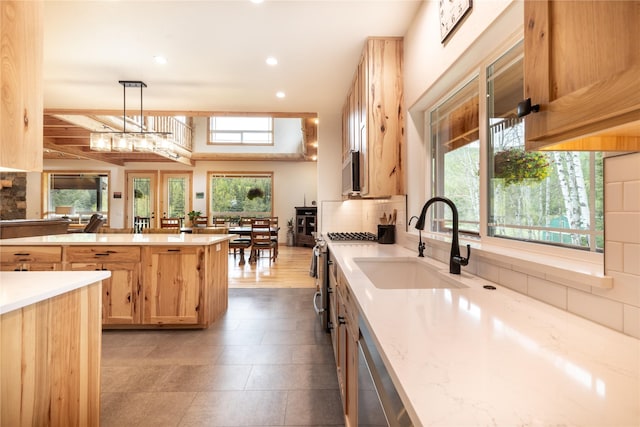 12520 Pinkham Creek Rd, Rexford, MT 59930 - kitchen featuring a sink, tasteful backsplash, light brown cabinetry, stainless steel appliances, and pendant lighting