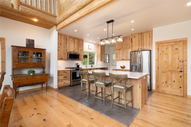 12520 Pinkham Creek Rd, Rexford, MT 59930 - kitchen featuring stainless steel appliances, a center island, light wood-style flooring, a breakfast bar area, and light countertops
