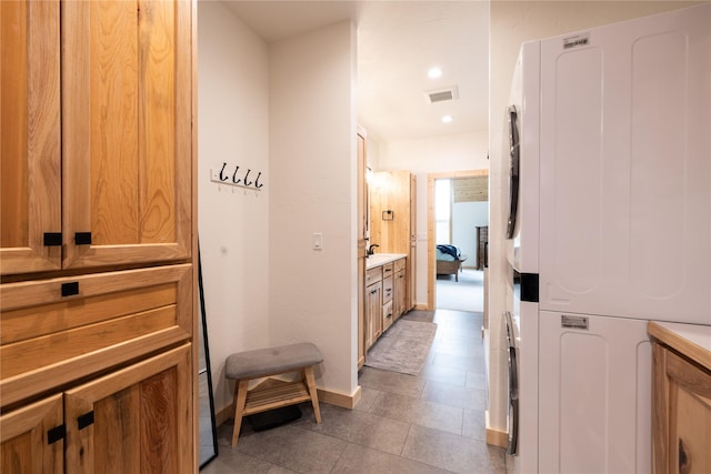12520 Pinkham Creek Rd, Rexford, MT 59930 - corridor featuring stacked washer and clothes dryer, recessed lighting, baseboards, a sink, and light tile patterned floors