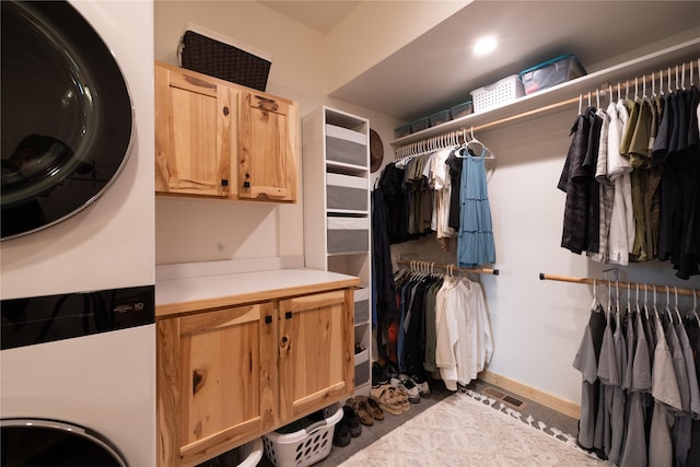 12520 Pinkham Creek Rd, Rexford, MT 59930 - washroom with cabinet space, stacked washer and clothes dryer, baseboards, and tile patterned floors