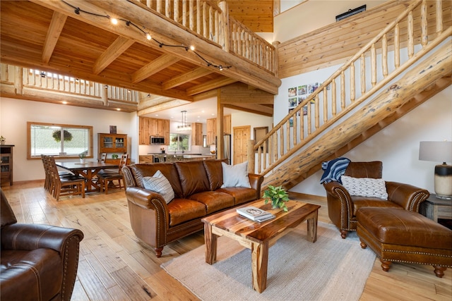 12520 Pinkham Creek Rd, Rexford, MT 59930 - living area featuring rail lighting, light wood-style floors, stairs, a high ceiling, and wood ceiling with exposed beams