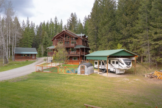 12520 Pinkham Creek Rd, Rexford, MT 59930 - view of front of home featuring a front yard, a view of trees, a carport, and an outbuilding