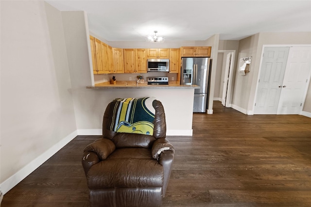 1091 Harmony Ct, Kalispell, MT 59901 - kitchen with appliances with stainless steel finishes, baseboards, dark wood-style floors, a peninsula, and light countertops