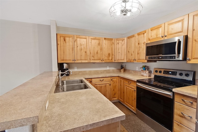 1091 Harmony Ct, Kalispell, MT 59901 - kitchen featuring appliances with stainless steel finishes, a sink, light brown cabinets, a peninsula, and light countertops