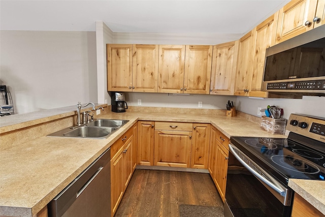 1091 Harmony Ct, Kalispell, MT 59901 - kitchen with appliances with stainless steel finishes, a sink, dark wood-style flooring, light countertops, and a peninsula