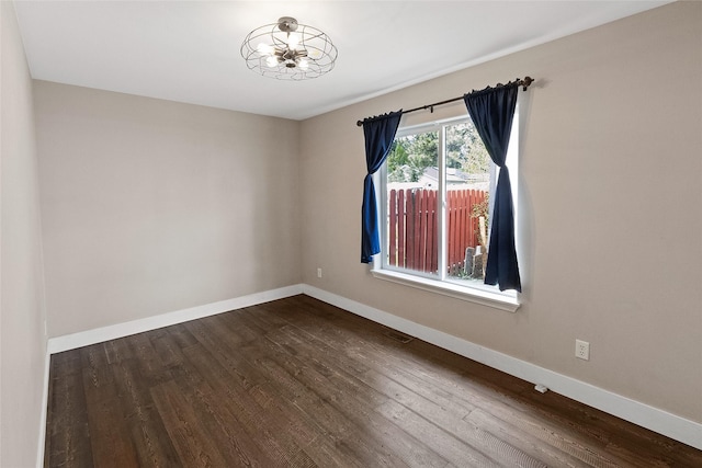 1091 Harmony Ct, Kalispell, MT 59901 - spare room with baseboards, dark wood-type flooring, and a chandelier
