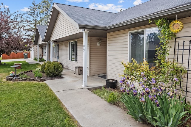 1091 Harmony Ct, Kalispell, MT 59901 - property entrance with roof with shingles, a yard, and covered porch