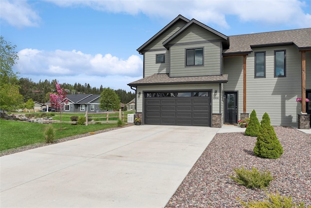 1066 Mill Creek Drive Mill Creek Drive, Bigfork, MT 59911 - view of front of home featuring an attached garage, concrete driveway, a shingled roof, and a front lawn