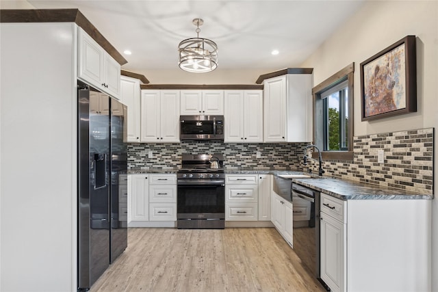 1066 Mill Creek Drive Mill Creek Drive, Bigfork, MT 59911 - kitchen with black appliances, dark countertops, light wood-type flooring, white cabinetry, and recessed lighting