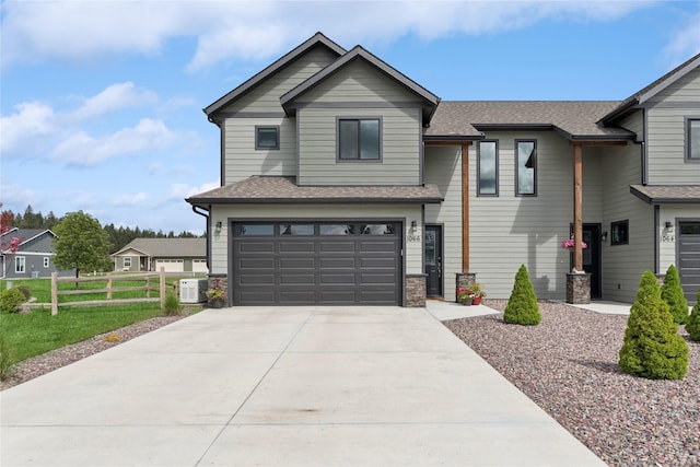 1066 Mill Creek Drive Mill Creek Drive, Bigfork, MT 59911 - view of front of house featuring an attached garage, concrete driveway, central AC unit, and a shingled roof