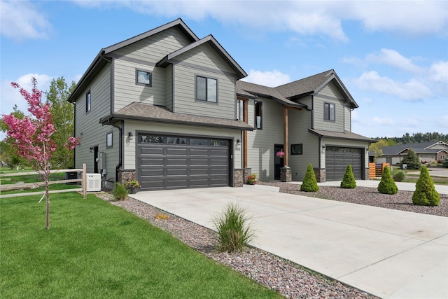 1066 Mill Creek Drive Mill Creek Drive, Bigfork, MT 59911 - view of front facade featuring an attached garage, concrete driveway, stone siding, and roof with shingles