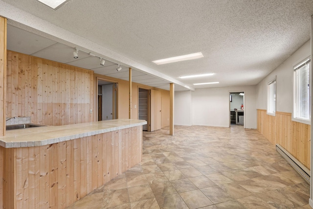 160 Sherwood Ln, Kalispell, MT 59901 - indoor wet bar with wooden walls, a baseboard radiator, track lighting, and a textured ceiling