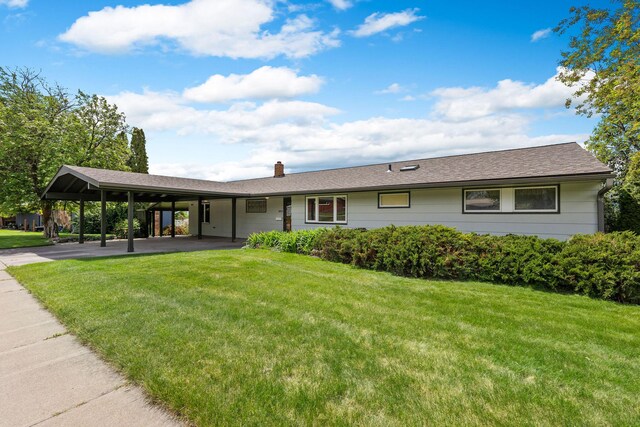 160 Sherwood Ln, Kalispell, MT 59901 - single story home featuring a front yard, a carport, a chimney, and driveway