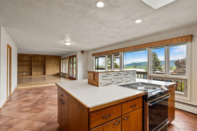 160 Sherwood Ln, Kalispell, MT 59901 - kitchen with range with electric stovetop, brown cabinets, open floor plan, light countertops, and a baseboard radiator