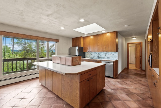 160 Sherwood Ln, Kalispell, MT 59901 - kitchen featuring stainless steel appliances, a skylight, baseboard heating, light countertops, and a center island