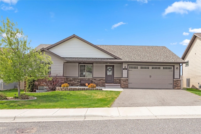89 Alyvia Ln, Butte, MT 59701 - view of front of home featuring an attached garage, asphalt driveway, a front lawn, a shingled roof, and covered porch