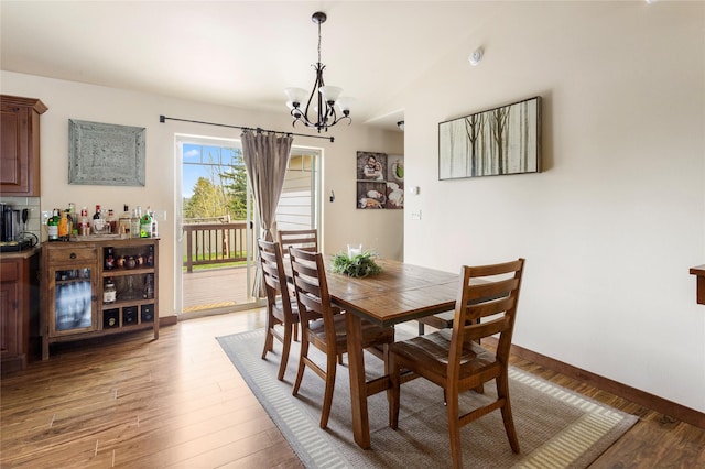 89 Alyvia Ln, Butte, MT 59701 - dining room with a chandelier, light wood-type flooring, lofted ceiling, a bar, and baseboards