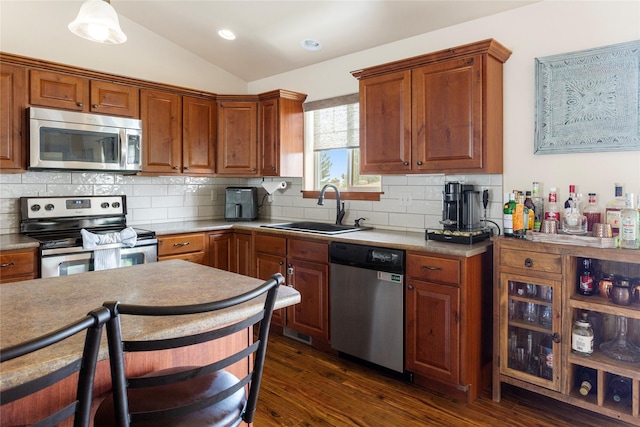 89 Alyvia Ln, Butte, MT 59701 - kitchen featuring appliances with stainless steel finishes, a sink, vaulted ceiling, dark wood-type flooring, and backsplash