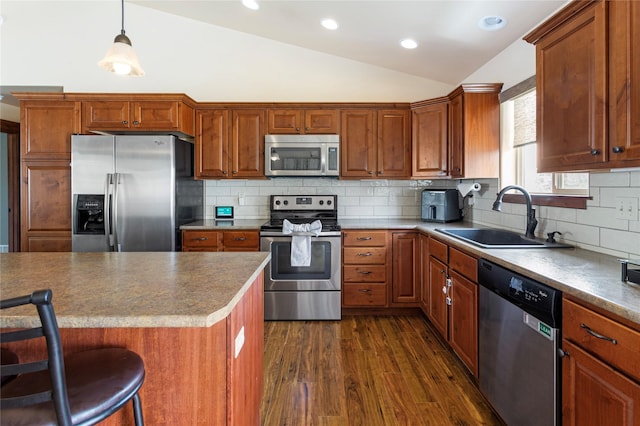 89 Alyvia Ln, Butte, MT 59701 - kitchen featuring appliances with stainless steel finishes, vaulted ceiling, a sink, dark wood-style floors, and brown cabinetry