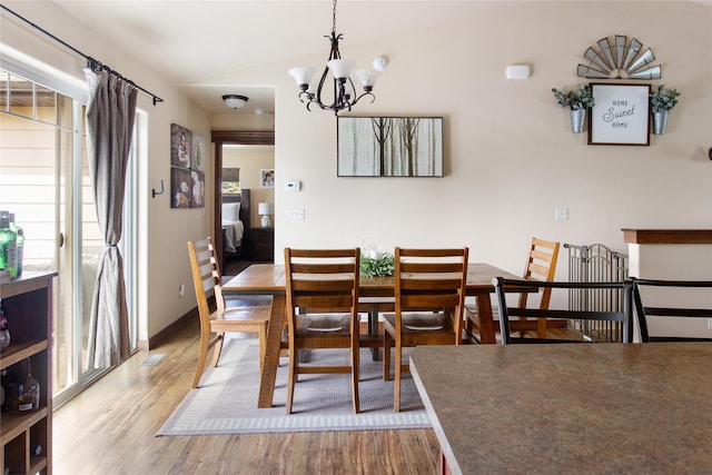 89 Alyvia Ln, Butte, MT 59701 - dining space featuring wood finished floors, a chandelier, and vaulted ceiling