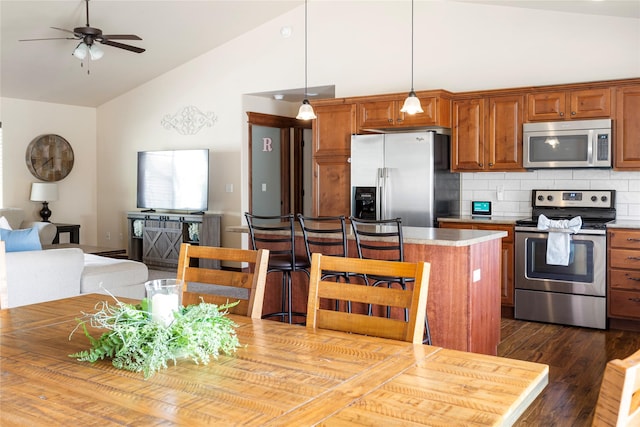 89 Alyvia Ln, Butte, MT 59701 - kitchen with stainless steel appliances, tasteful backsplash, light countertops, dark wood-style floors, and brown cabinetry