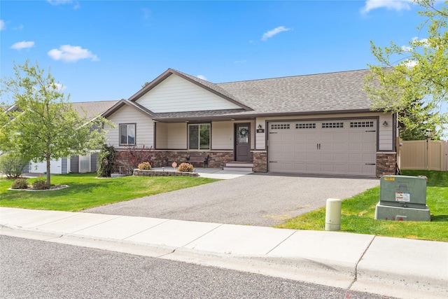 89 Alyvia Ln, Butte, MT 59701 - ranch-style home featuring an attached garage, driveway, a front lawn, stone siding, and a shingled roof