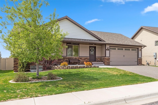 89 Alyvia Ln, Butte, MT 59701 - view of front of house featuring a garage, driveway, roof with shingles, stone siding, and covered porch