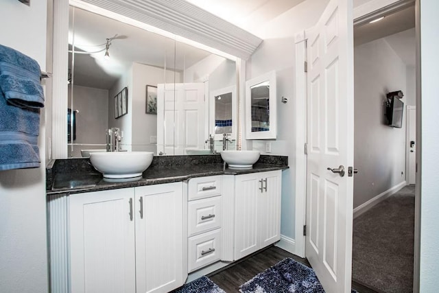 883 Saint Andrews Dr, Columbia Falls, MT 59912 - full bathroom featuring double vanity, baseboards, and wood finished floors