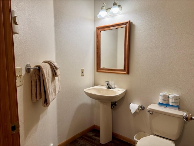 883 Saint Andrews Dr, Columbia Falls, MT 59912 - half bath with toilet, wood finished floors, baseboards, and a sink