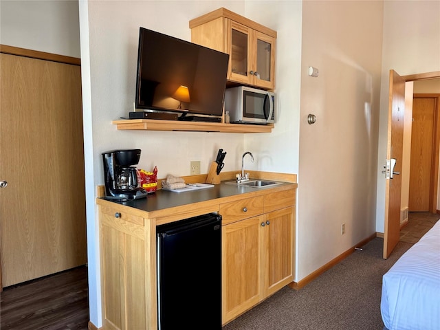 883 Saint Andrews Dr, Columbia Falls, MT 59912 - kitchen featuring black refrigerator, stainless steel microwave, a sink, glass insert cabinets, and baseboards