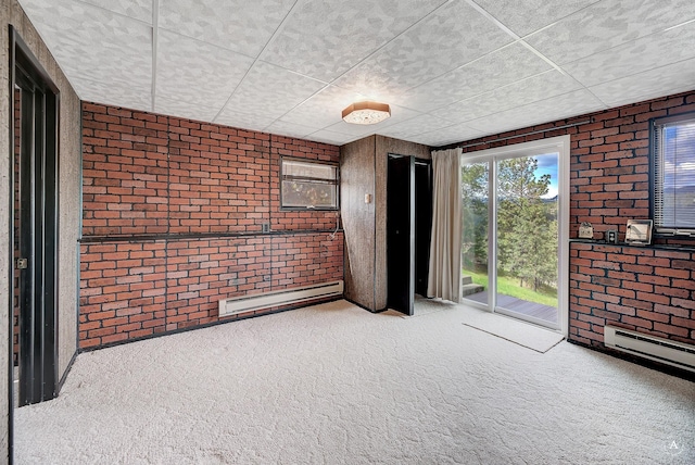 15 Vigilante Trl, Clancy, MT 59634 - empty room with a baseboard radiator, carpet flooring, brick wall, and a paneled ceiling