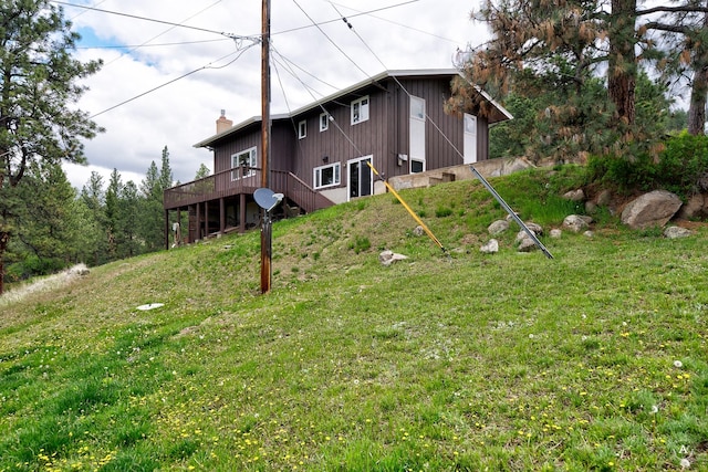 15 Vigilante Trl, Clancy, MT 59634 - rear view of house featuring a deck, a lawn, a garage, and a chimney