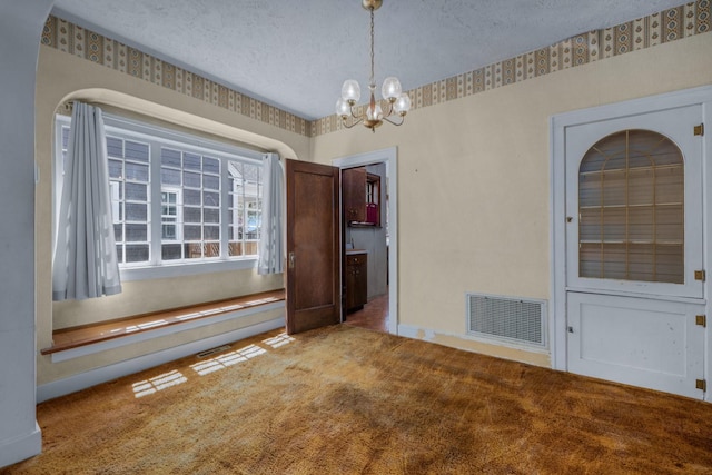 414 Somers Ave, Whitefish, MT 59937 - unfurnished dining area with a textured ceiling, a chandelier, carpet floors, and baseboards