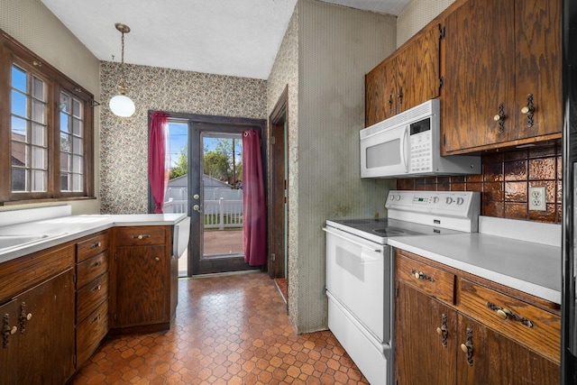 414 Somers Ave, Whitefish, MT 59937 - kitchen featuring white appliances, wallpapered walls, light countertops, and hanging light fixtures