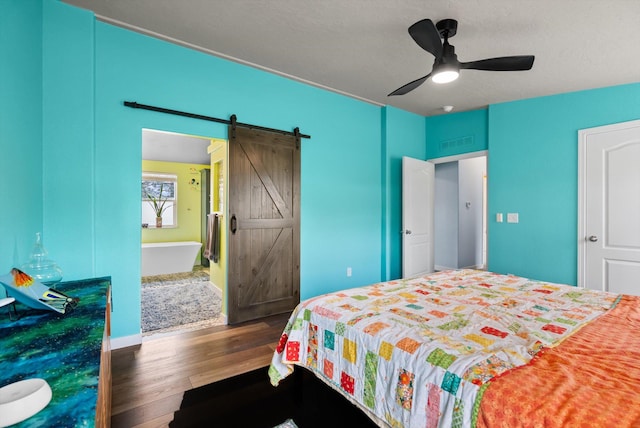 245 Blanchard Lake Rd, Whitefish, MT 59937 - bedroom featuring a barn door, wood finished floors, and a ceiling fan