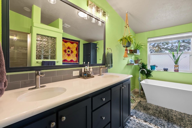 245 Blanchard Lake Rd, Whitefish, MT 59937 - full bath featuring lofted ceiling, double vanity, a freestanding bath, and backsplash