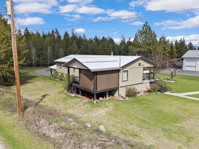 245 Blanchard Lake Rd, Whitefish, MT 59937 - view of property exterior with a lawn, a metal roof, a forest view, and stairs