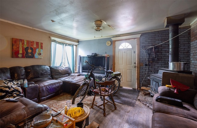 103 6th St, Alberton, MT 59820 - living area featuring a wood stove, hardwood / wood-style flooring, a ceiling fan, and crown molding