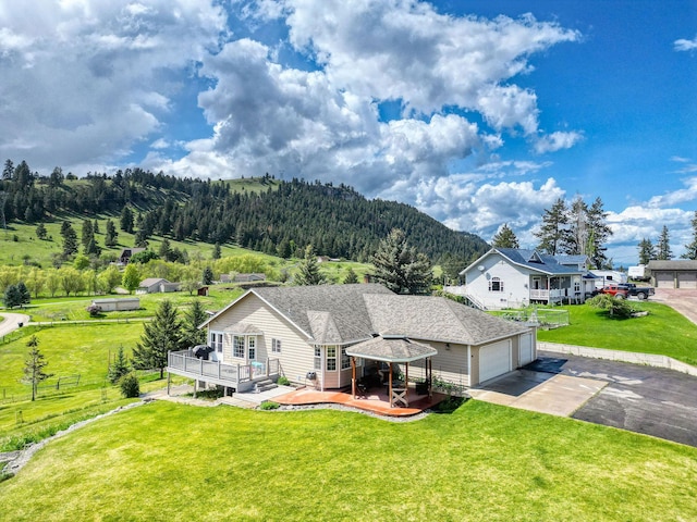 30 Knapp Ln, Kalispell, MT 59901 - view of front of home with a deck, concrete driveway, a garage, and a wooded view
