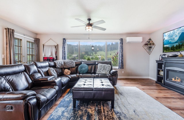 30 Knapp Ln, Kalispell, MT 59901 - living room with an AC wall unit, wood finished floors, a ceiling fan, baseboards, and a glass covered fireplace